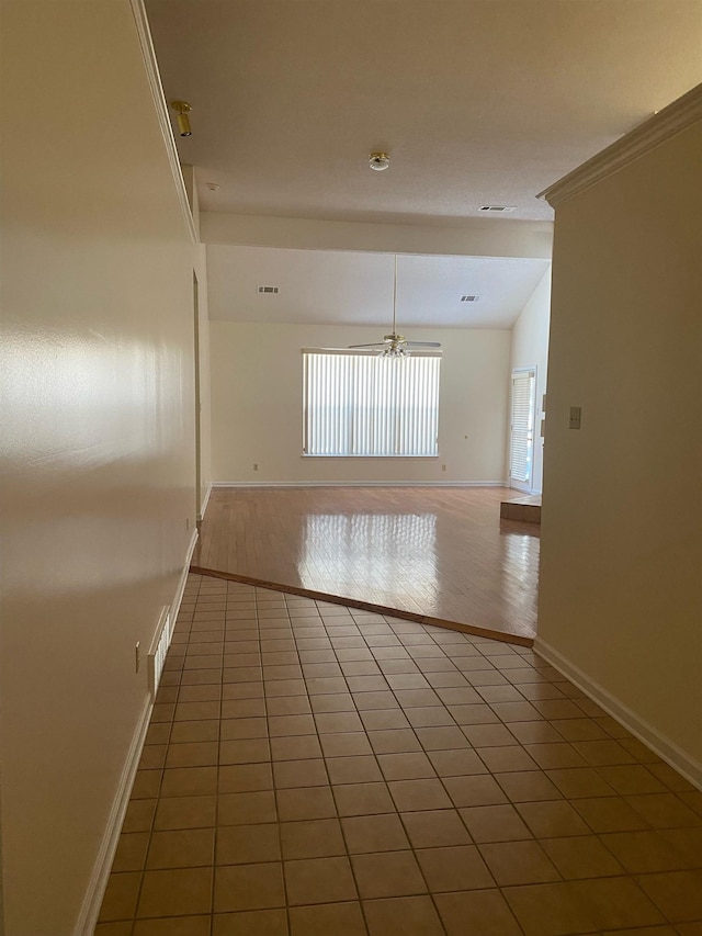 tiled empty room featuring lofted ceiling