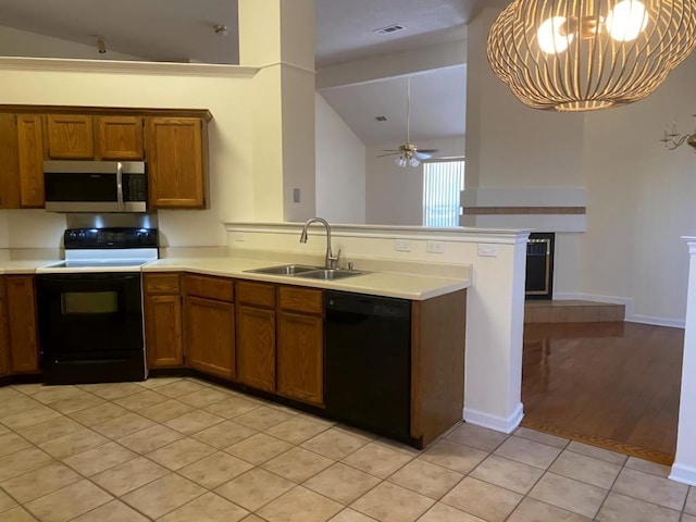 kitchen featuring sink, black appliances, light tile patterned flooring, vaulted ceiling, and kitchen peninsula