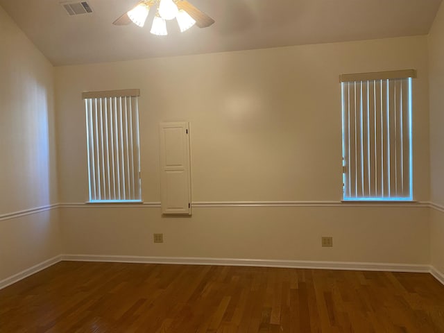 empty room featuring dark wood-type flooring and ceiling fan