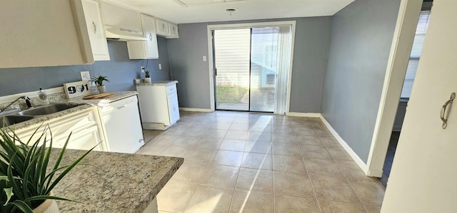 kitchen with white cabinetry, sink, light stone countertops, and range