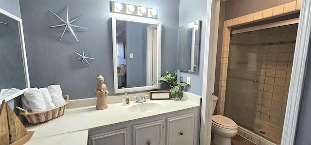 bathroom with a shower with door, vanity, and toilet