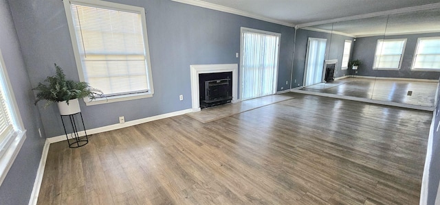 unfurnished living room with plenty of natural light, ornamental molding, and dark hardwood / wood-style floors