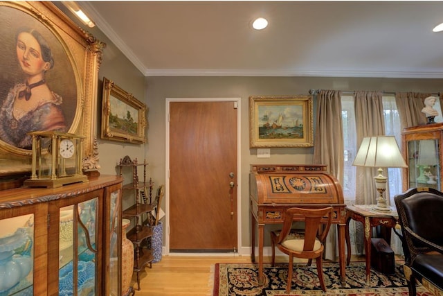 sitting room featuring ornamental molding and light wood-type flooring