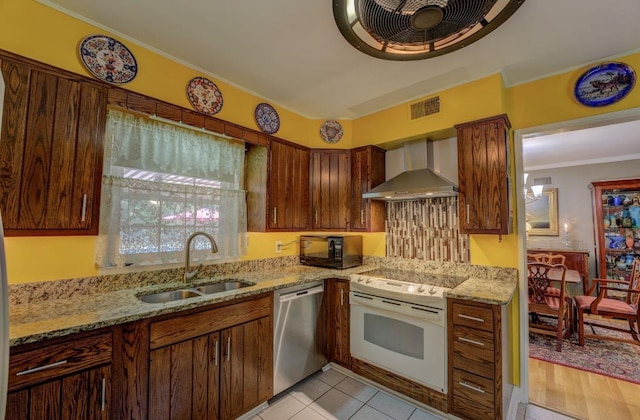 kitchen featuring wall chimney range hood, white electric range, sink, light stone countertops, and stainless steel dishwasher