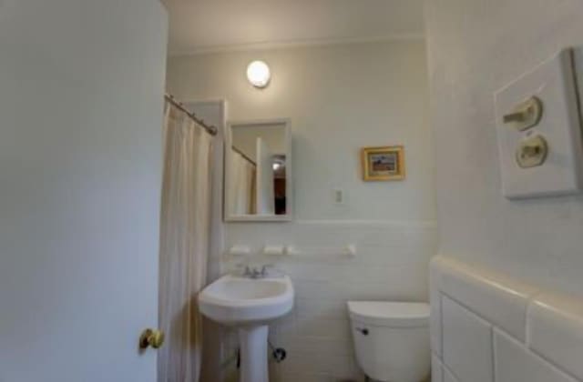 bathroom with curtained shower and toilet