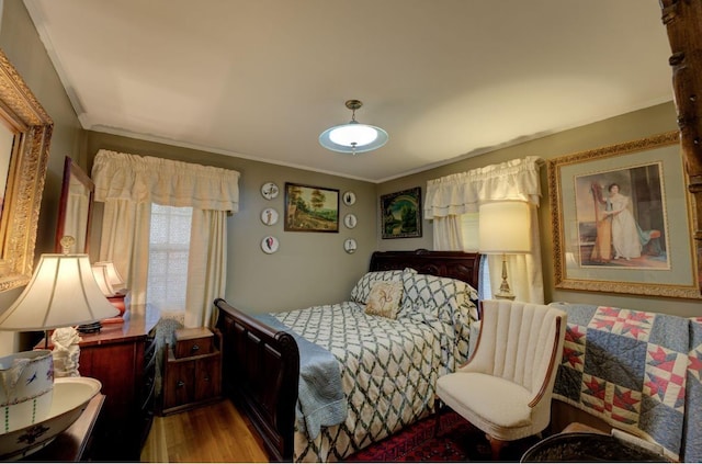 bedroom with ornamental molding and light hardwood / wood-style flooring