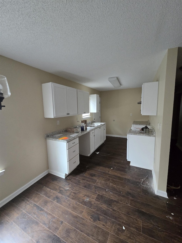 kitchen with sink, a textured ceiling, white cabinets, and dark hardwood / wood-style flooring