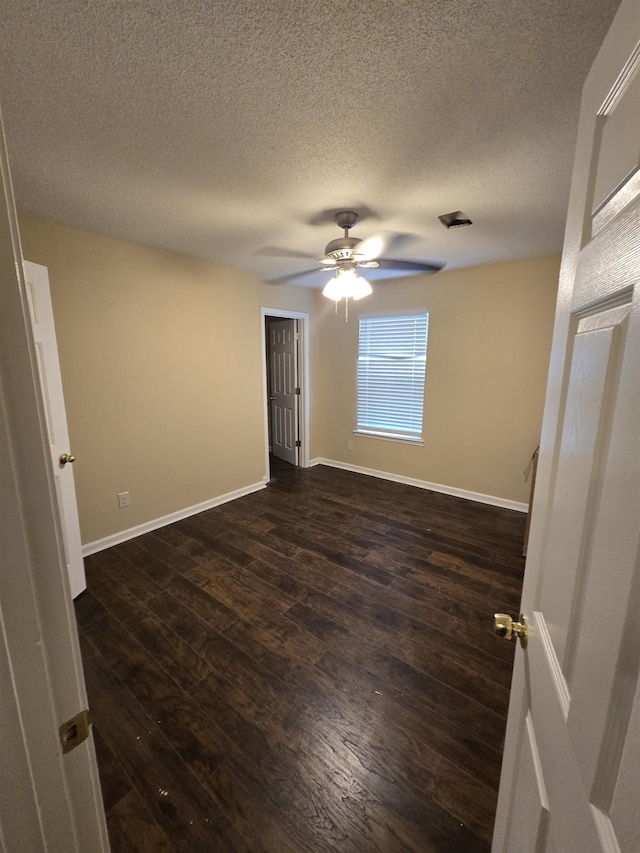 unfurnished room featuring dark hardwood / wood-style floors, a textured ceiling, and ceiling fan