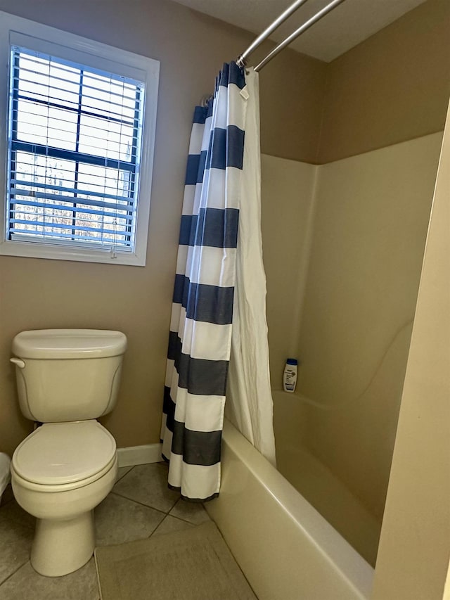 bathroom featuring tile patterned floors, toilet, and shower / bath combo with shower curtain