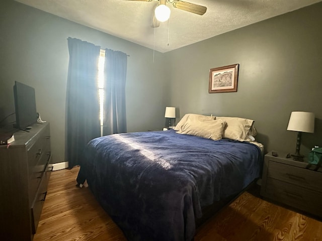 bedroom featuring hardwood / wood-style flooring, ceiling fan, and a textured ceiling