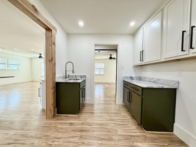 kitchen with ceiling fan, light hardwood / wood-style flooring, sink, and white cabinets