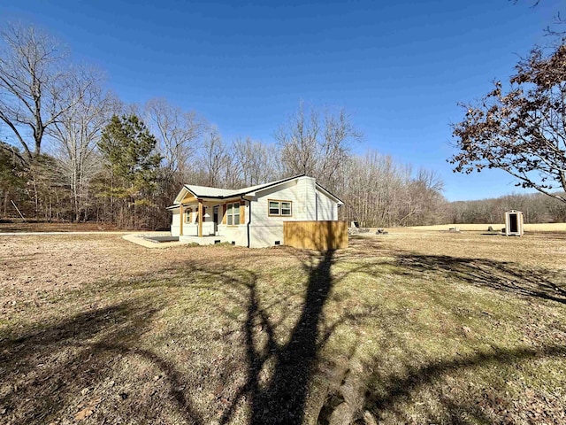 view of side of home featuring a porch and a lawn