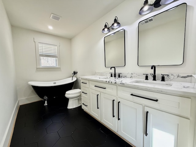 bathroom featuring tile patterned flooring, toilet, vanity, and a tub to relax in