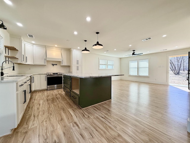 kitchen featuring electric stove, sink, pendant lighting, white cabinets, and custom exhaust hood