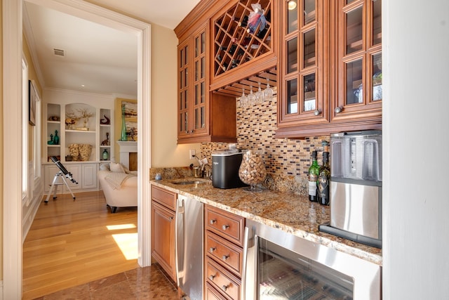 kitchen featuring sink, wine cooler, backsplash, light stone countertops, and dark wood-type flooring