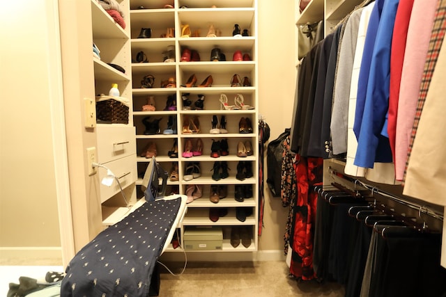 spacious closet featuring light colored carpet