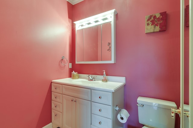 bathroom featuring ornamental molding, vanity, and toilet