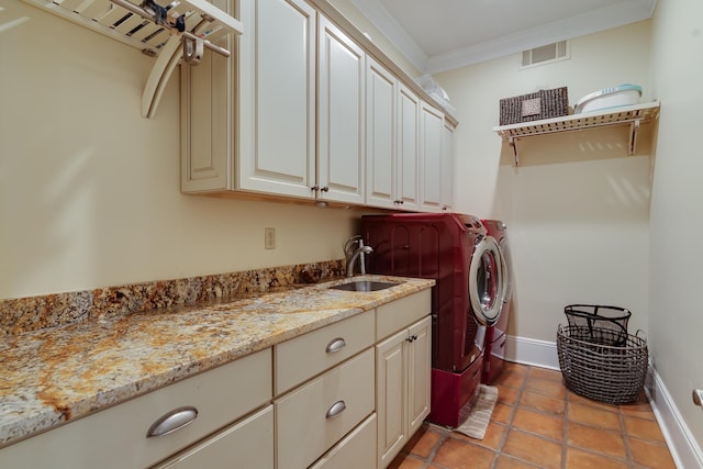 washroom with sink, cabinets, light tile patterned floors, crown molding, and washing machine and dryer