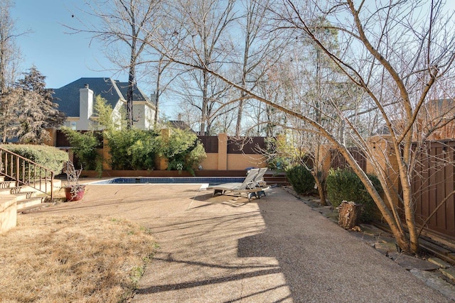 view of yard featuring a fenced in pool and a patio