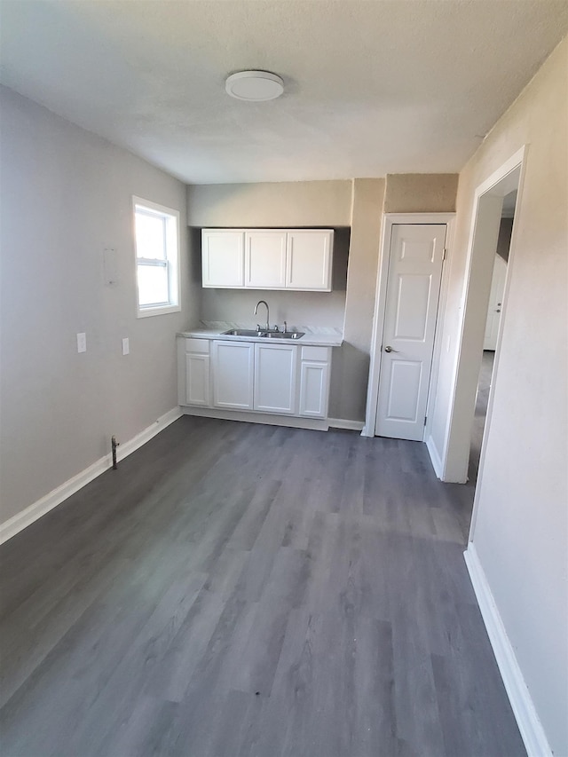 kitchen featuring dark hardwood / wood-style floors, sink, and white cabinets