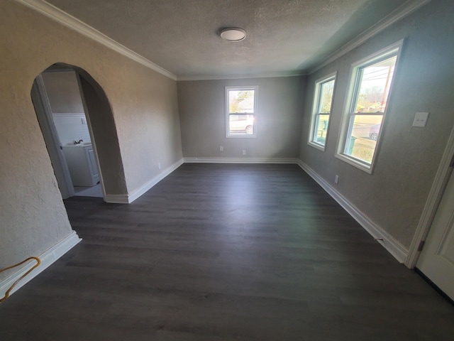 spare room featuring ornamental molding, dark hardwood / wood-style floors, washer / dryer, and a textured ceiling