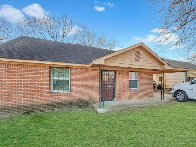 ranch-style house featuring a carport and a front lawn