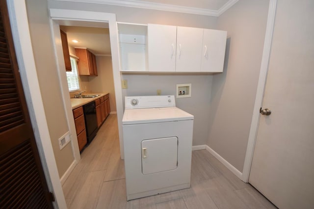 clothes washing area with washer / clothes dryer, sink, cabinets, crown molding, and light hardwood / wood-style flooring