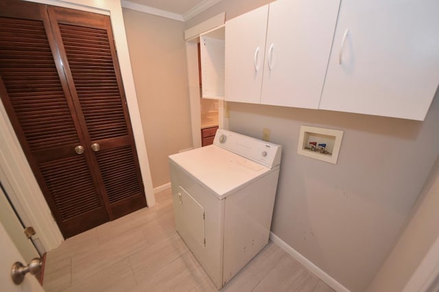 clothes washing area featuring crown molding, washer / dryer, and cabinets