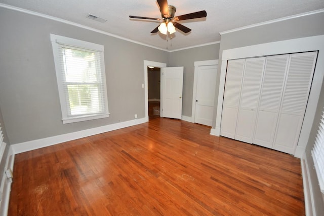 unfurnished bedroom with crown molding, wood-type flooring, and ceiling fan