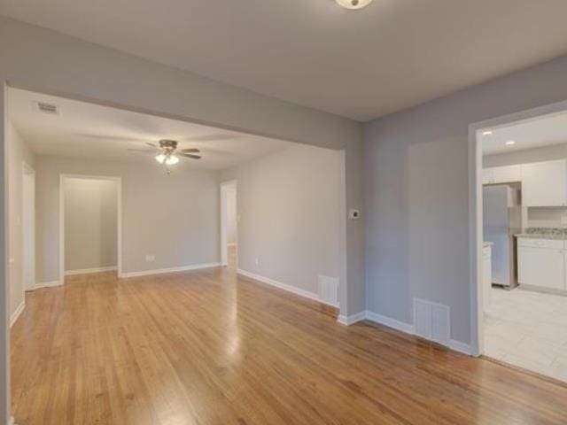 empty room featuring ceiling fan and light wood-type flooring