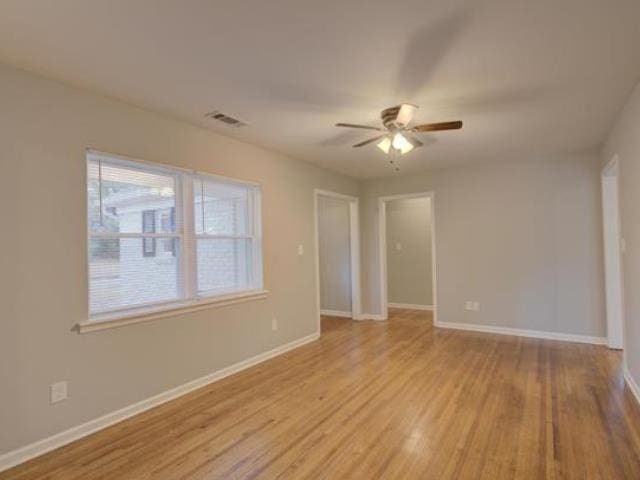 unfurnished room with ceiling fan and light wood-type flooring