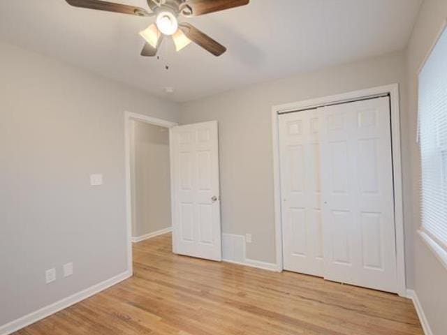 unfurnished bedroom with ceiling fan, a closet, and light wood-type flooring