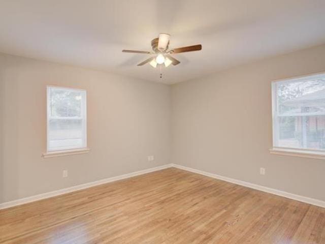 unfurnished room with a wealth of natural light, light hardwood / wood-style floors, and ceiling fan