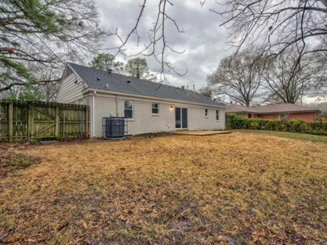 back of property featuring a yard and cooling unit