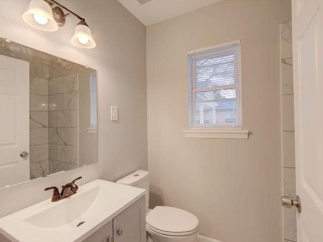 bathroom with vanity, toilet, and walk in shower