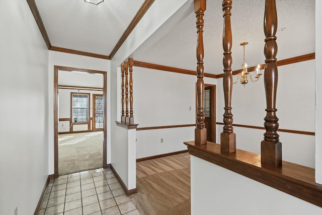 corridor with an inviting chandelier, light colored carpet, crown molding, and a textured ceiling