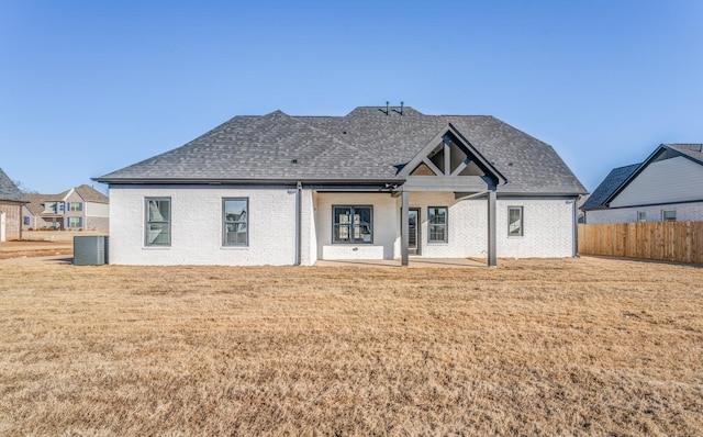 back of property featuring central AC unit, a patio area, and a lawn