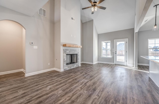 unfurnished living room featuring dark wood-type flooring, high vaulted ceiling, and a wealth of natural light