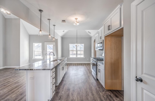 kitchen with sink, vaulted ceiling, white cabinets, and appliances with stainless steel finishes