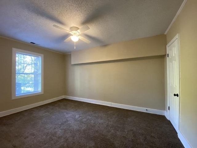 spare room featuring ceiling fan, crown molding, a textured ceiling, and dark carpet