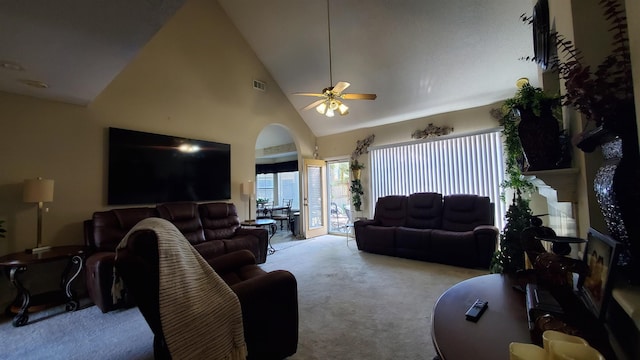 carpeted living room with ceiling fan and high vaulted ceiling