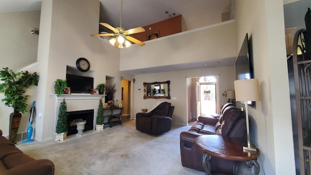 carpeted living room with ceiling fan and a towering ceiling