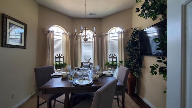 dining room with a chandelier and a textured ceiling