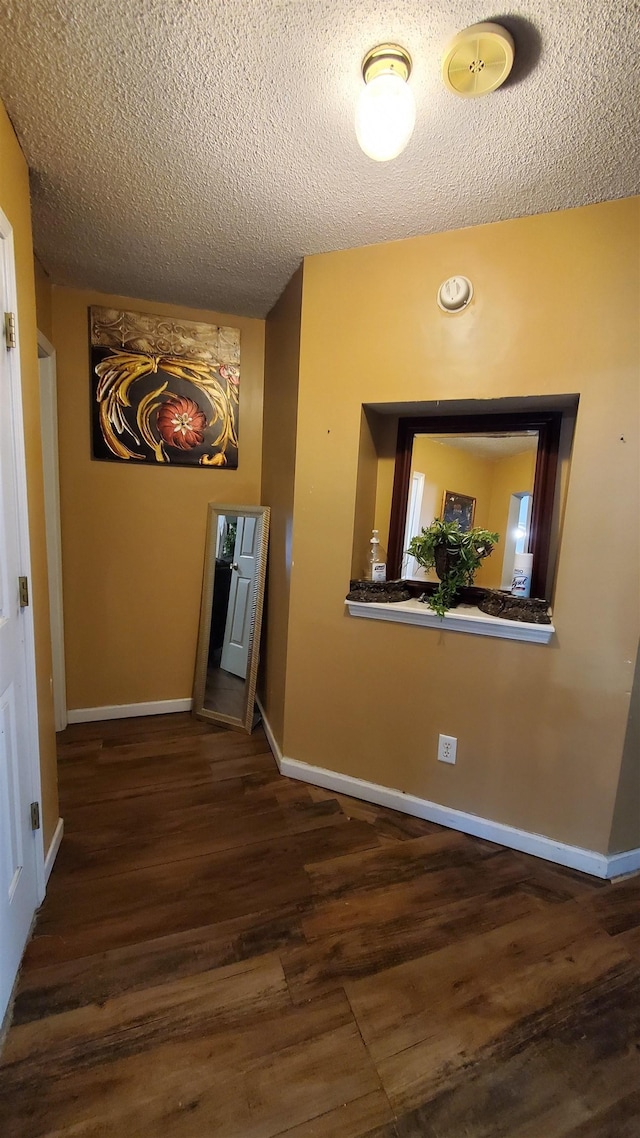 hallway featuring dark hardwood / wood-style floors and a textured ceiling