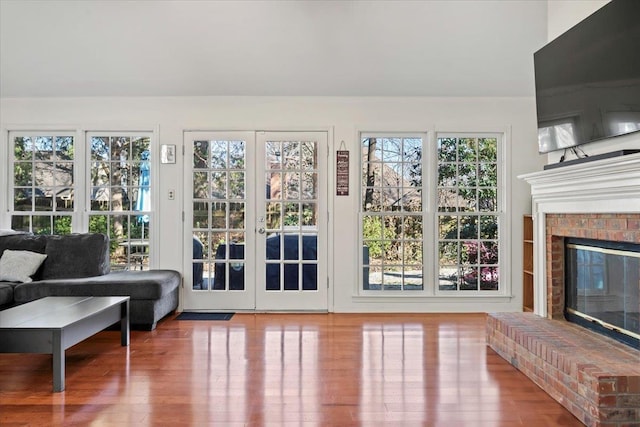 doorway to outside featuring wood-type flooring and a brick fireplace