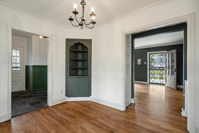 unfurnished dining area with an inviting chandelier, crown molding, and a wealth of natural light