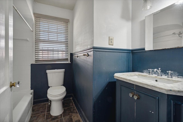 bathroom with vanity, a bathtub, and toilet