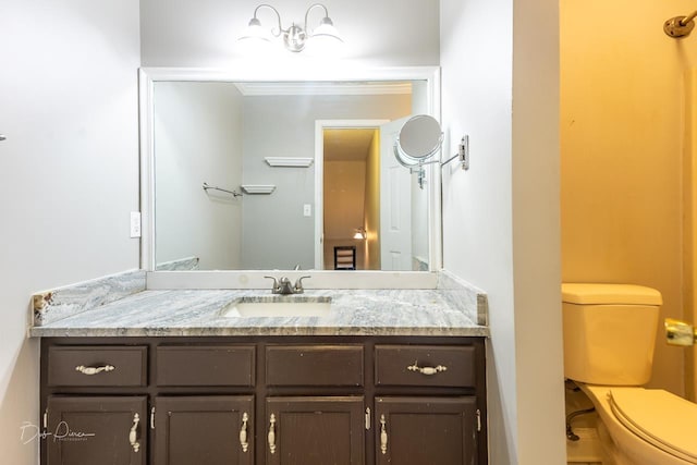 bathroom with vanity, crown molding, and toilet