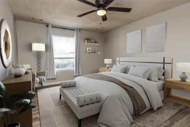 bedroom featuring hardwood / wood-style flooring, ceiling fan, and a textured ceiling