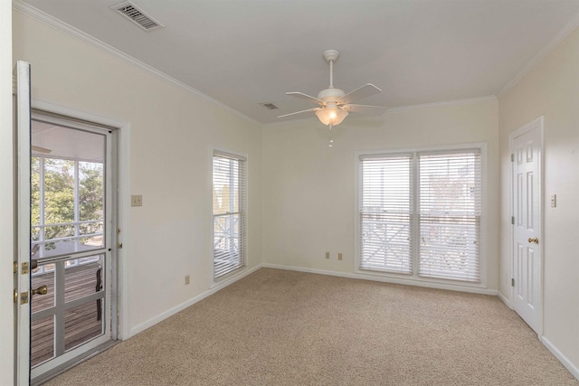 carpeted spare room featuring crown molding and ceiling fan